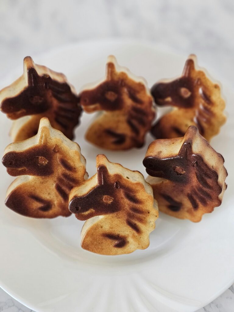 A charming plate of homemade unicorn-shaped cookies perfect for dessert lovers.